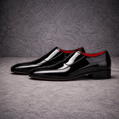 Pair of black patent leather shoes with red lining
